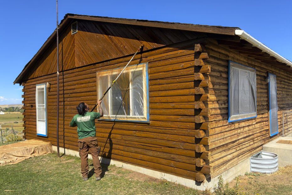 Employee Staining A Log Cabin