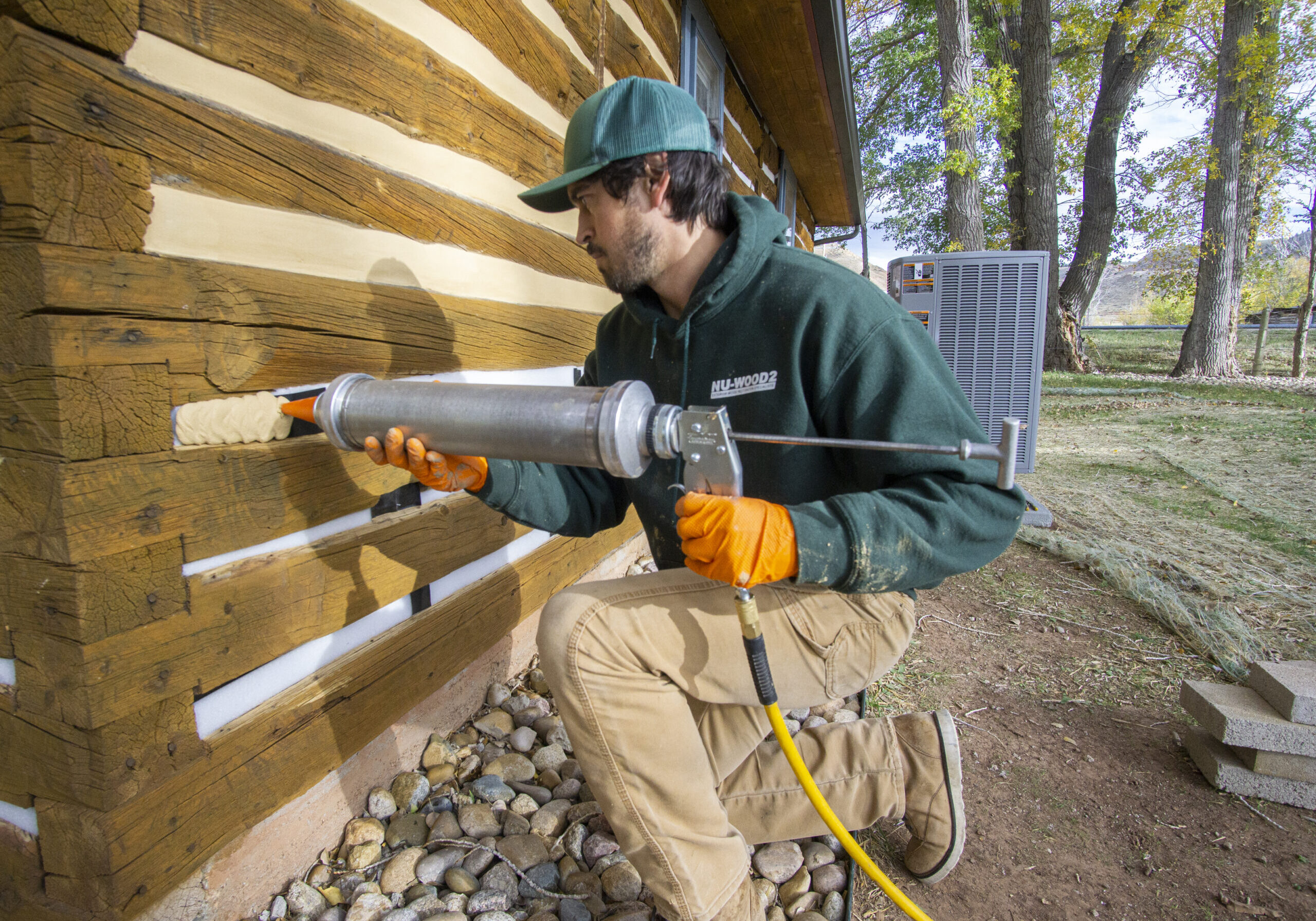 Founder Chinking A Log Cabin