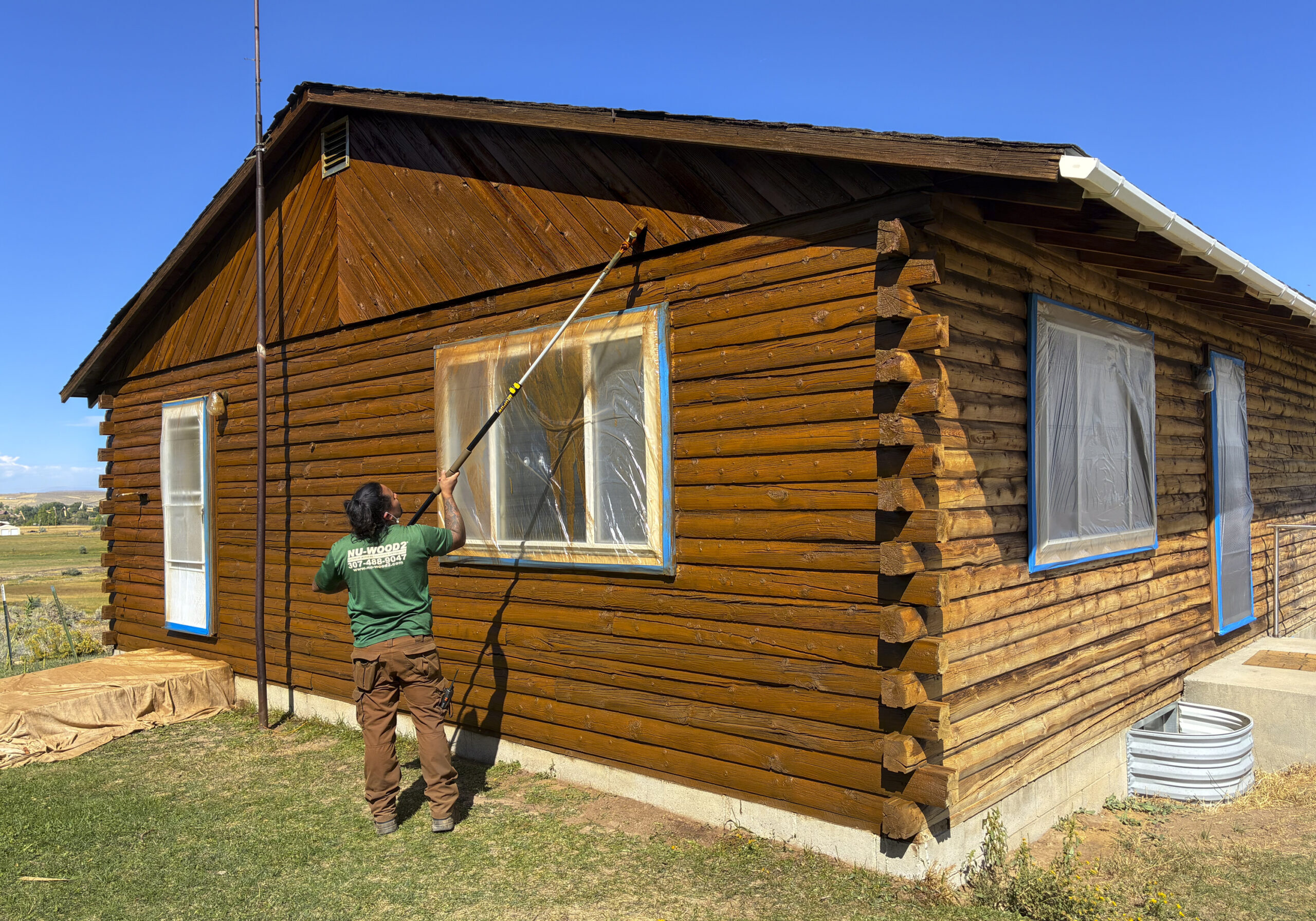 Employee Staining A Log Cabin
